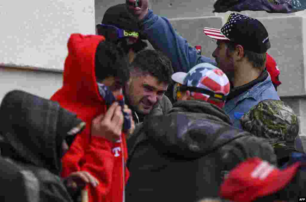 Um apoiante de Trump é atingido com gás lacrimogéneo enquanto manifestantes tentavam invadir o Capitólio dos EUA em Washington, DC, em 6 de Janeiro de 2021. Os apoiantes de Donald Trump invadiram uma sessão do Congresso realizada a 6 de Janeiro, para certificar a vitória de Joe Biden nas eleições, desencadeando caos e violência sem precedentes no coração da democracia americana&nbsp;