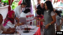 Petugas KPPS di TPS 18 Menteng melayani warga yang ingin mencoblos (15/2). (VOA/Ahadian Utama)