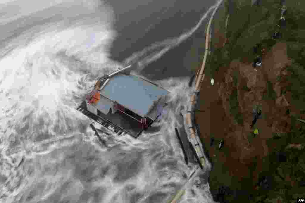This aerial view shows people looking at the collapsed pier at the Santa Cruz Wharf in Santa Cruz, California, Dec. 23, 2024. A pier collapsed into the ocean and floated away off, weather authorities said, as the region was pounded by a powerful storm.