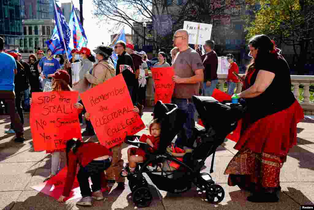A supporter of U.S. President Donald Trump and her children carry placards at a "Stop the Steal" protest at the Wisconsin State Capitol.