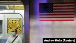 Seorang pelaju mengenakan masker saat di dalam kereta bawah tanah ketika jumlah kasus baru COVID-19 akibat varian Delta terus bertambah di Kota New York, AS, 26 Juli 2021. (Foto: Andrew Kelly/Reuters)