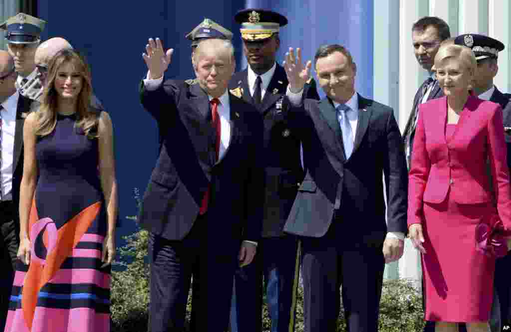 U.S. President Donald Trump, left, waves along with Poland's President Andrzej Duda, as U.S. First Lady Melania Trump, left and Poland's first lady Agata Kornhauser-Duda, right, stand by, in Krasinski Square, in Warsaw, July 6, 2017.