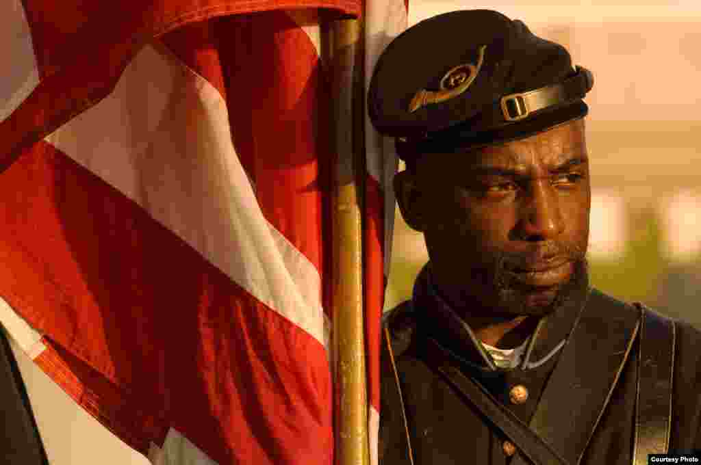A Union soldier reenactor stands by an 1864 U.S. flag at Gettysburg's Lincoln Cemetery on Remembrance Day. A special ceremony is held for black soldiers who continue to be buried there. (© Kenneth Garrett Photography)