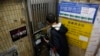 A mainland Chinese tourist checks the door of the closed Causeway Bay Bookstore which is known for gossipy titles about Chinese political scandals and other sensitive issues that are popular with visiting tourists from the mainland, in Hong Kong, Feb. 5, 2016. 