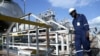 FILE - A worker walks by an oil well at the Toma South oil field in Ruweng state, South Sudan, Aug. 25, 2018.
