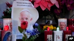 Lilin-lilin menyala di dekat foto Paus Fransiskus di luar Poliklinik Agostino Gemelli, Roma, 23 Februari 2025, tempat ia dirawat sejak 14 Februari. (Foto: AP)