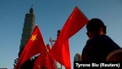 一些支持中國的台灣人在台北101大樓前舉著中國國旗。(該照片拍攝時間為2016年8月22日，路透社提供)
