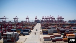 FILE - A US cargo ship (back) at the Yangshan Deep-Water Port, an automated cargo wharf, in Shanghai. 