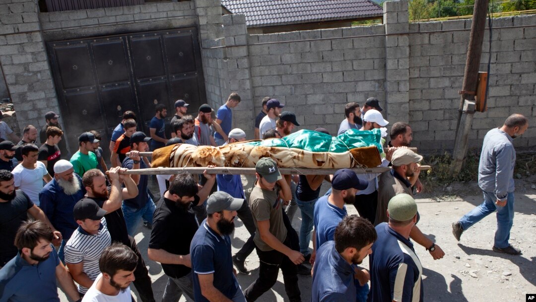 People carry the body of the victim who has been identified as Zelimkhan Khangoshvili, a Georgian Muslim who fought against Russia in the Second Chechen War during the funeral in Duisi village, the Pankisi Gorge valley, in Georgia, Aug. 29, 2019.
