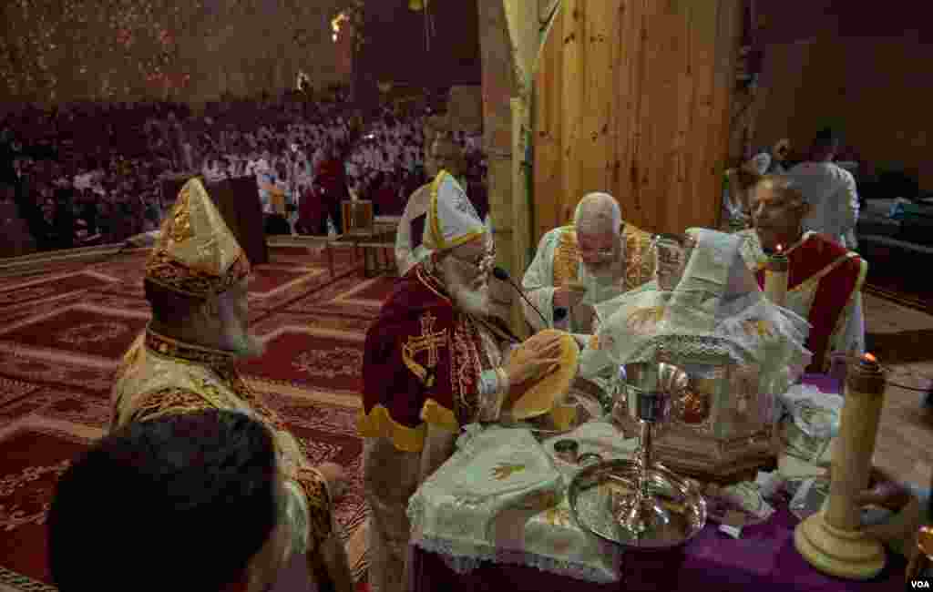Coptic priests sing in praise as they consecrate bread during Christmas Mass. (Hamada Elrasam/VOA)
