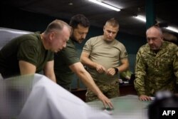 FILE - Ukrainian President Volodymyr Zelenskyy, second from left, and Colonel-General Oleksandr Syrskyi, left, visit the brigades engaged in offensive operations in the Donetsk region on Sept. 5, 2023. (Ukrainian Presidential Press Office via AFP)