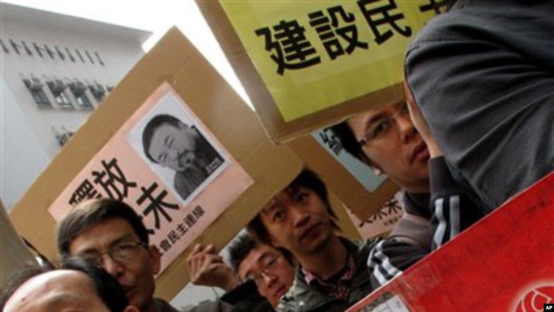 Human rights protesters hold a rally, carrying the picture of Ai Weiwei, one of its most famous contemporary Chinese artists outside the China Liaison Office in Hong Kong, April 5, 2011