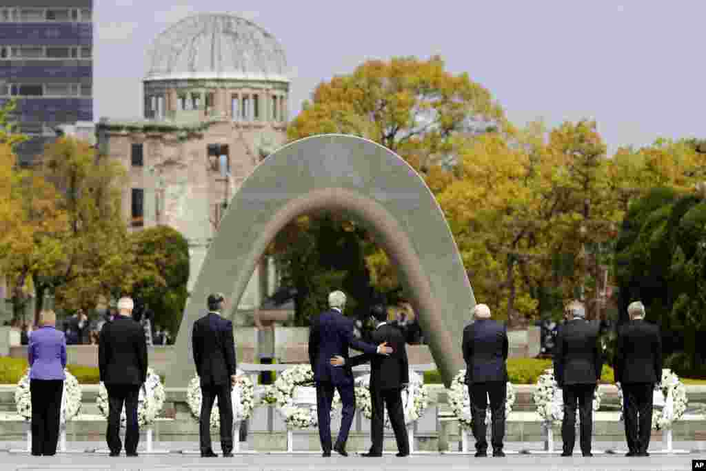 U.S. Secretary of State John Kerry, center left, puts his arm around Japan's Foreign Minister Fumio Kishida, center right, after they and fellow G-7 foreign ministers laid wreaths at the cenotaph at Hiroshima Peace Memorial Park in Hiroshima, Japan, April 11, 2016.