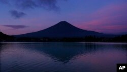 ພູໄຟຟູຈິ ຂອງຍີ່ປຸ່ນ ສະ​ທ້ອນ​ກັບ​ທະ​ເລ​ສາບ ຄາ​ວາ​ກຸ​ຊິ ໃນ​ຕອນເຊົ້າ​ມືດ, 7 ສິງ​ຫາ 2019.