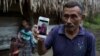 Domingo Caal Chub, 61, holds a smartphone displaying a photo of his granddaughter, Jakelin Caal Maquin, in Raxruha, Guatemala, Dec. 15, 2018. The 7-year-old girl died in a Texas hospital, two days after being taken into custody by U.S. Border Patrol agent