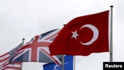 Bendera Turki (kanan) berkibar antara lain bendera anggota NATO selama Dewan Atlantik Utara (NAC) di markas Aliansi di Brussel, Belgia, 28 Juli 2015. (Foto: REUTERS/Francois Lenoir)