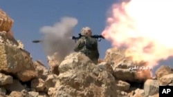 Cuplikan video yang dirilis hari Sabtu, 22 Juli 2017 menunjukkan seorang pejuang Hezbollah menembakkan pelontar granat selama bentrokan dengan militan yang terkait al-Qaida di perbatasan Lebanon-Suriah (foto: Syrian Central Military Media, via AP)