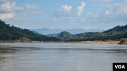 A yellow flag marks the site on the Mekong River in northern Laos where the government plans to build the Luang Prabang hydropower dam. (Zsombor Peter/VOA)