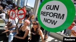 Protesters hold signs as they call for a reform of gun laws three days after the shooting at Marjory Stoneman Douglas High School, at a rally in Fort Lauderdale, Florida, Feb. 17, 2018. 