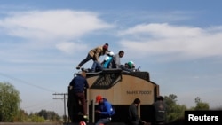 Central American migrants, moving in a caravan through Mexico, travel on a wagon of a freight train after stopping it on the rail line, in Michoacan state, Mexico, April 17, 2018. 