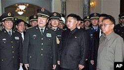 北韓領導人金正日和他的兒子金正恩(中)在平壤接待中國軍事代表團(資料照片)