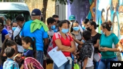 Para migran asal Venezuela mengantri untuk menunggu giliran vaksinasi COVID-19 di La Parada, area komersil yang berada di perbatasan Kolombia dan Venezuela, di wilayah Cucuta, Kolombia, pada 13 Oktober 2021. (Foto: AFP/Schneyder Mendoza)