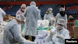 Volonteri pakuju kutije donirane pomoći za starije građane u Beogradu. Foto: REUTERS