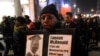 FILE - A protester holds a sign as people rally in memory of 17-year-old Laquan McDonald, who was shot 16 times by police officer Jason Van Dyke in Chicago, Nov. 24, 2015.