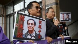 Pro-democracy Civic Party protesters carry portraits of missing booksellers Lee Bo, left, and Gui Minhai, outside the Chinese Liaison Office in Hong Kong, Jan. 19, 2016. China said on Feb. 17, 2016, Lee Bo was assisting a police enquiry and did not want publicity.