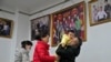 Seorang pria menggendong cucunya usai foto bersama anggota keluarga lainnya di sebuah studio foto di Beijing, China, 17 Januari 2023. (Foto: Andy Wong/AP Photo)