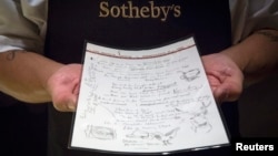 Seorang pegawai Sotheby's menunjukkan lirik bertuliskan tangan milik Bob Dylan untuk lagu 'Like a Rolling Stone' yang menjadi bagian koleksi; 'A Rock and Roll History: Presley to Punk' di rumah lelang Sotheby's di New York, 20 Juni 2014.