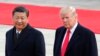 FILE - U.S. President Donald Trump, right, walks with Chinese President Xi Jinping during a welcome ceremony at the Great Hall of the people in Beijing, Nov. 9, 2017. 