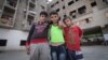 Syrian youngsters pose in front of the Ouzai building. With some families here for more than three years, many have grown up here. (Photo - J. Owens/VOA)
