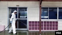 Seorang pekerja membersihkan pengaruh radiasi di Taman Kanak-Kanak Yasawa di Minami-Soma, 20 kilometer dari pusat nuklir Dai-ichi di Fukushima (18/8).