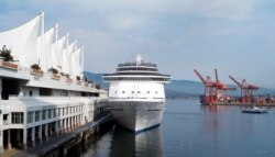 FILE - The Carnival Spirit cruise ship sits docked at Canada Place as a seabus (R) commuter boat makes its way across the inner harbor in Vancouver, British Columbia, Sept.17, 2008.