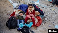 Children rest outside, as Palestinians arrive in Rafah after they were evacuated from Nasser Hospital in Khan Younis due to the Israeli ground operation, amid the ongoing conflict between Israel and Hamas, in the southern Gaza Strip, Feb. 15, 2024.