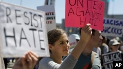 A woman holds up a sign at a rally in San Francisco, Aug. 25, 2017, ahead of politically conservative rallies scheduled this weekend.