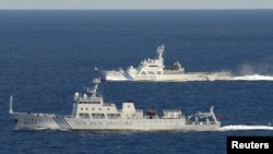 日本共同通信9月15日拍摄的中国海监船51号（前）和日本海监船（后）在东海有争议岛屿附近的海域行驶
