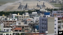 FILE - MV-22 Osprey aircraft are seen at the U.S. Marines' Futenma Air Station and the surrounding area from an observation deck at a park in Ginowan, Okinawa Prefecture, southern Japan, March 23, 2015.
