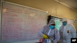Petugas mendesinfeksi ruang kelas di Ivory Park Secondary School di timur Johannesburg, Afrika Selatan, 28 Mei 2020, menjelang dibukanya kembali sekolah bagi pelajar kelas 7 dan 12, 1 Juni 2020.