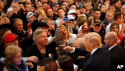 People greet Republican presidential candidate Donald Trump, bottom right, after he spoke at a rally at the Surf Ballroom in Clear Lake, Iowa, Jan. 9, 2016.