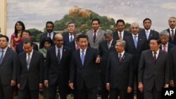 Chinese President Xi Jinping, center, shows the way to the guests who attended the signing ceremony of the Asian Infrastructure Investment Bank at the Great Hall of the People in Beijing, Oct. 24, 2014.