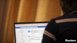 A man opens the Facebook page on his computer to fact check coronavirus disease (COVID-19) information, in Abuja, Nigeria March 19, 2020. Picture taken March 19, 2020. REUTERS/Afolabi Sotunde