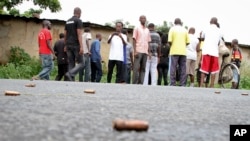 A man looks across at spent bullet casings lying on a street in the Nyakabiga neighborhood of Bujumbura, Burundi, Saturday, Dec. 12, 2015.