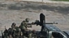 Unidentified troops drive past in the city of Abidjan, Ivory Coast, April 1, 2011