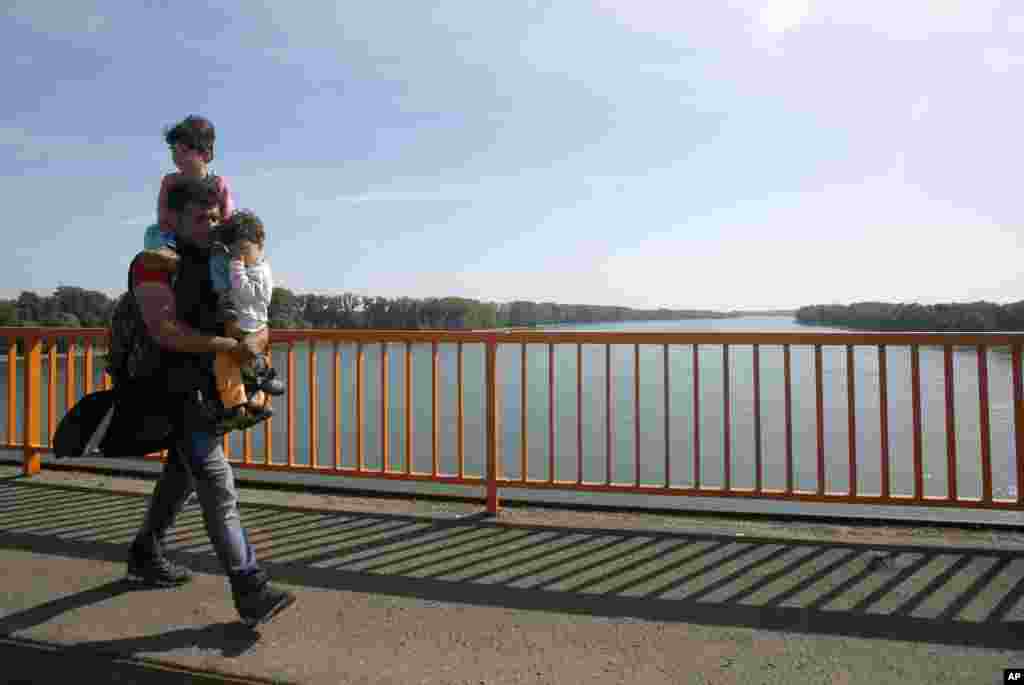 這名男子帶兩個孩子步行跨過一座多瑙河大橋,進入克羅地亞。