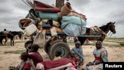 Satu keluarga asal Sudan tampak beristirahat di tengah perjalanan mereka melarikan diri dari wilayah konflik di Darfur and bergerak menuju Chad, pada 26 Juli 2023. (Foto: Reuters/Zohra Bensemra)