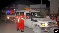 Medical workers wait by ambulances ready to transport wounded, after a bomb attack at an ice cream shop in Mogadishu, Somalia, Nov. 27, 2020