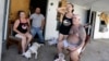 Debra Harmon holds her head as she recall riding out Hurricane Harvey in their apartment they lack of resources they have available including electricity, Aug. 29, 2017, in Aransas Pass, Texas. 