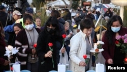 Warga berkumpul untuk menyalakan lilin setelah penembakan massal selama perayaan Tahun Baru Imlek di Monterey Park, California, AS, 24 Januari 2023. 